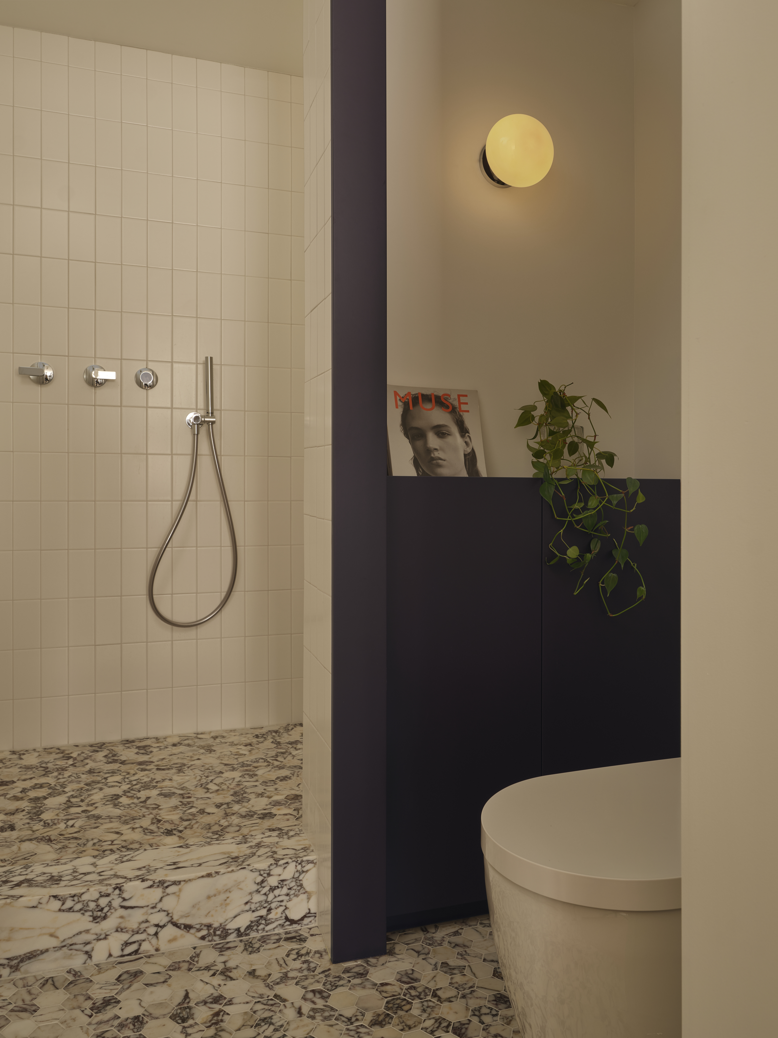 Ensuite with white tiled shower, Calacatta Viola marble floor, and alabaster sconce
