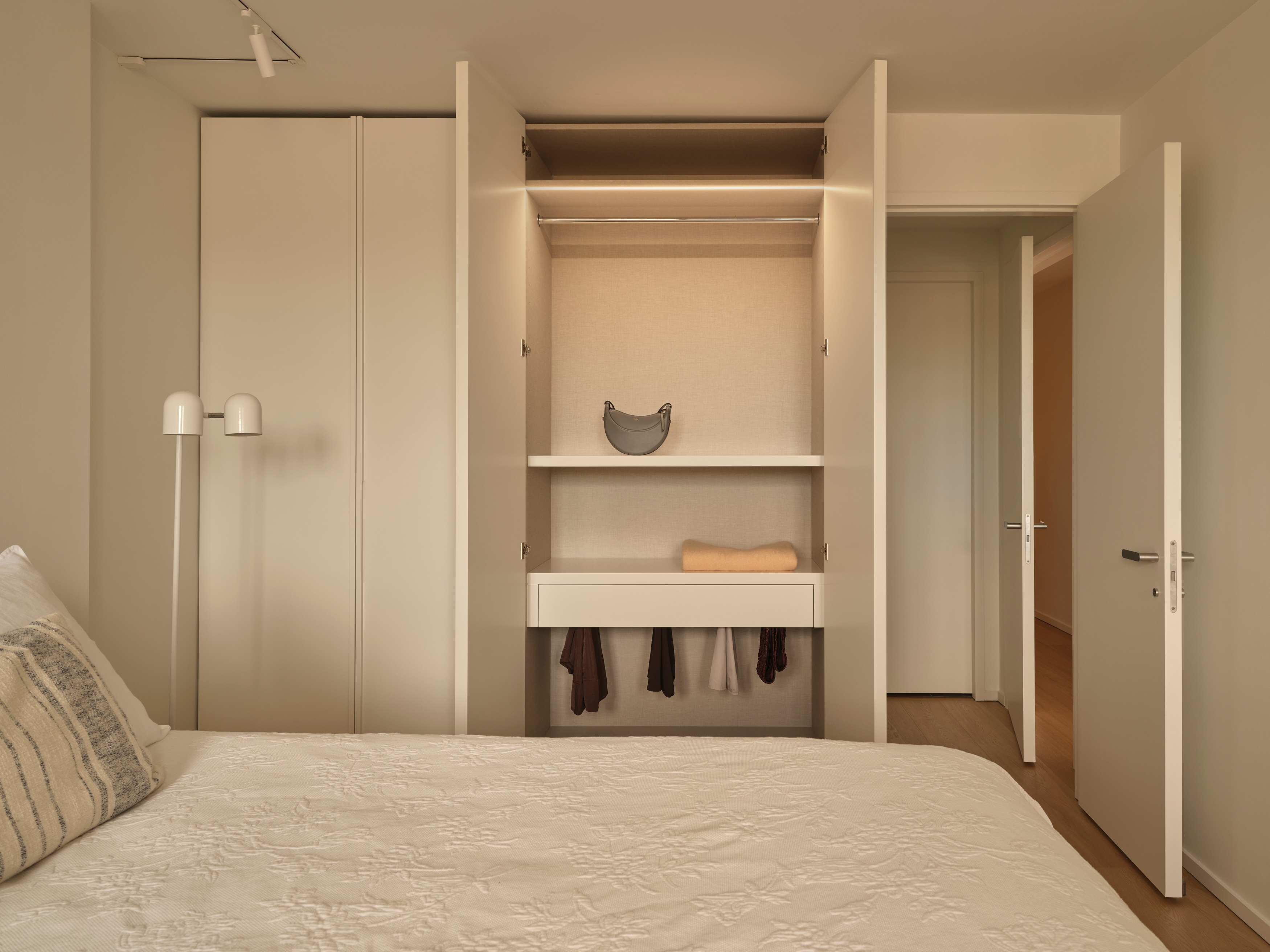 Custom wardrobe with illuminated interior, shelving, and hanging storage