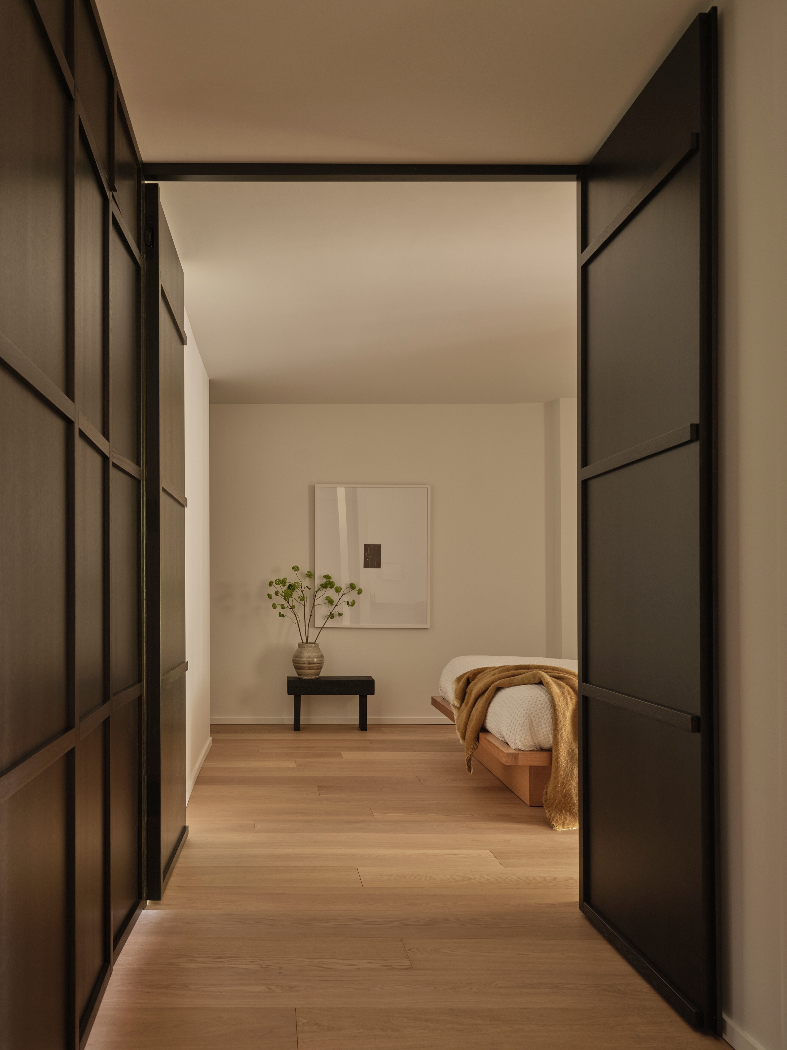 Renovated foyer lined with floor-to-ceiling dark-stained oak wardrobe panels