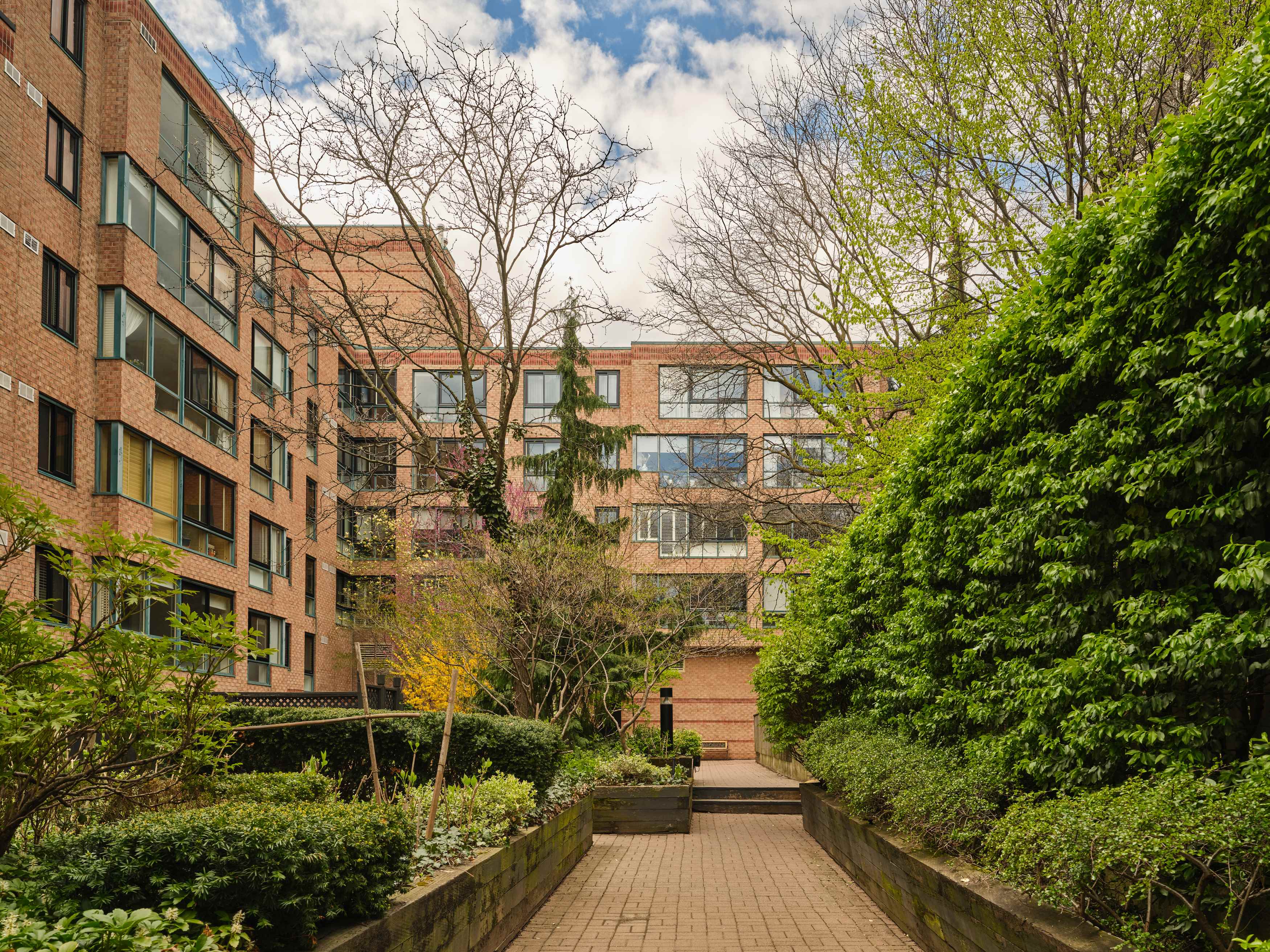 Brick low-rise exterior and landscaped courtyard garden at 225 Davenport Road
