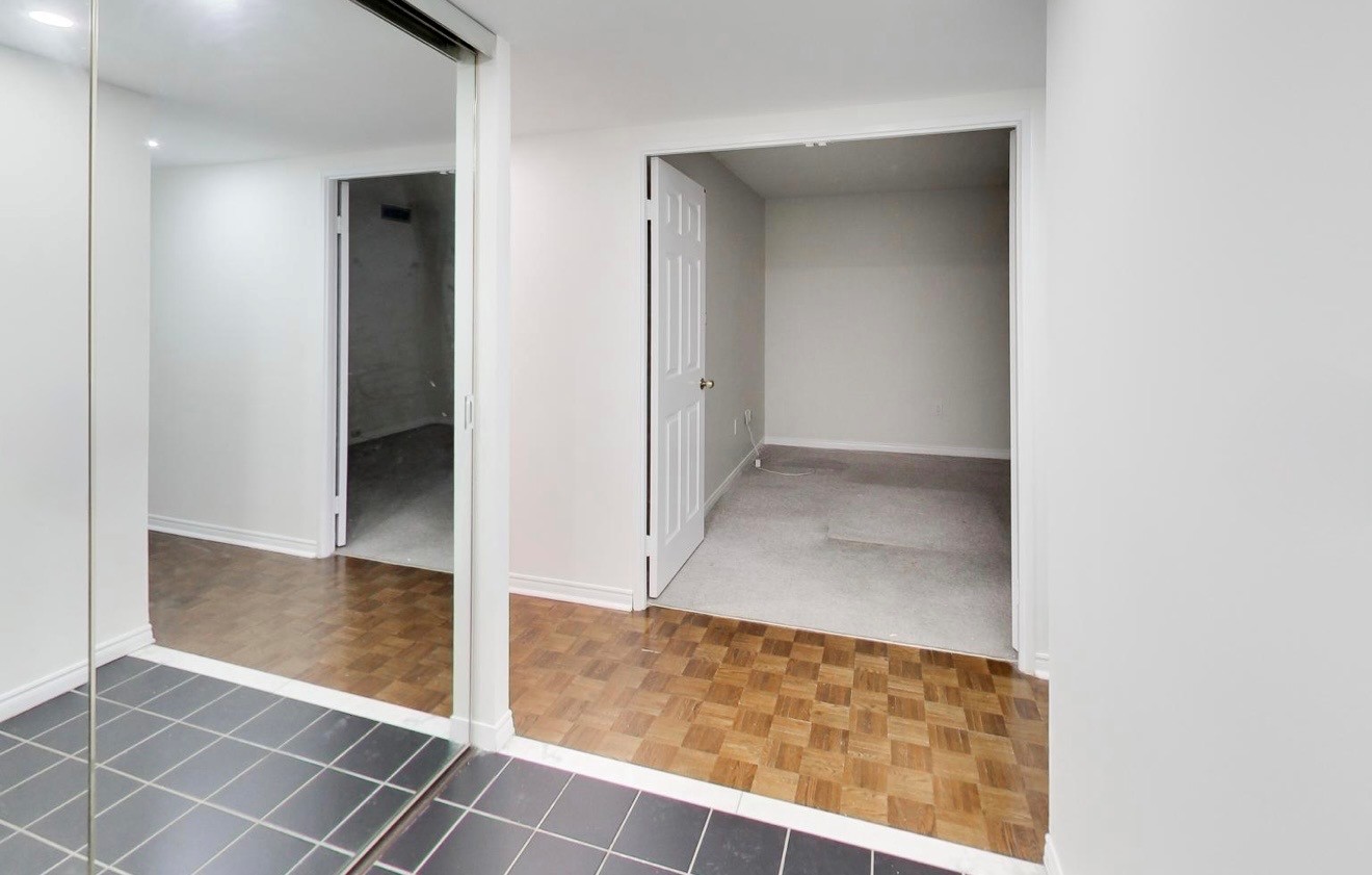 Original entry with mirrored sliding closet doors and mismatched flooring before renovation